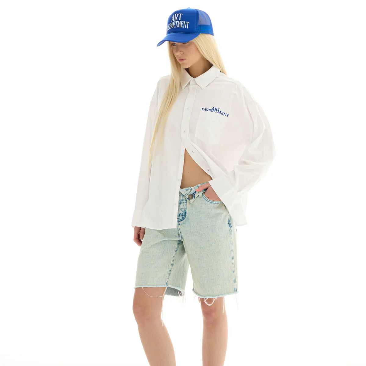 Person wearing a white shirt, light green shorts, and a blue cap on a white background