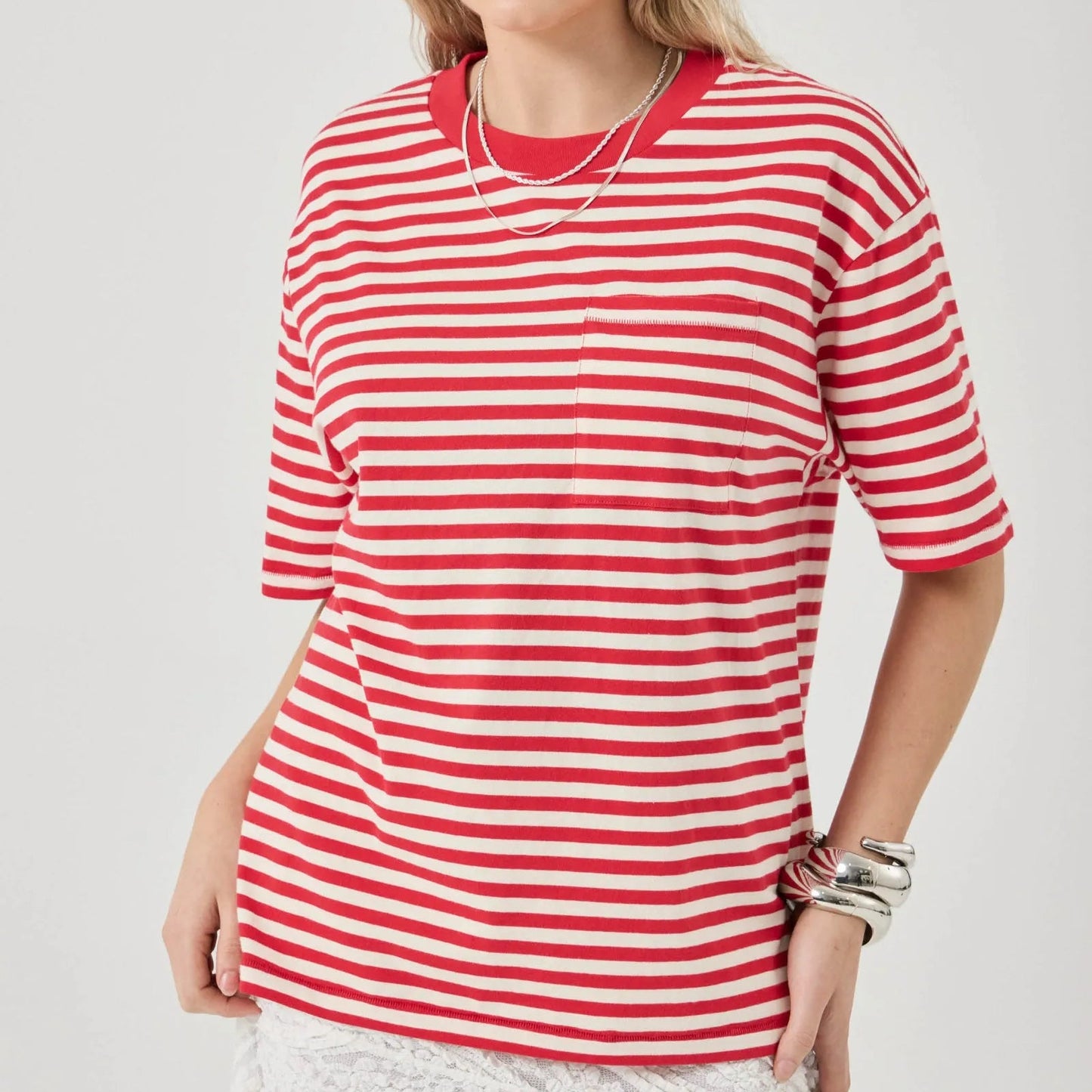 Woman wearing a red and white striped shirt on a plain background