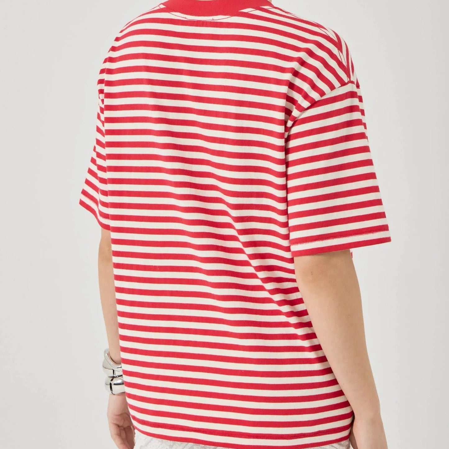 Person wearing a red and white striped shirt on a plain background