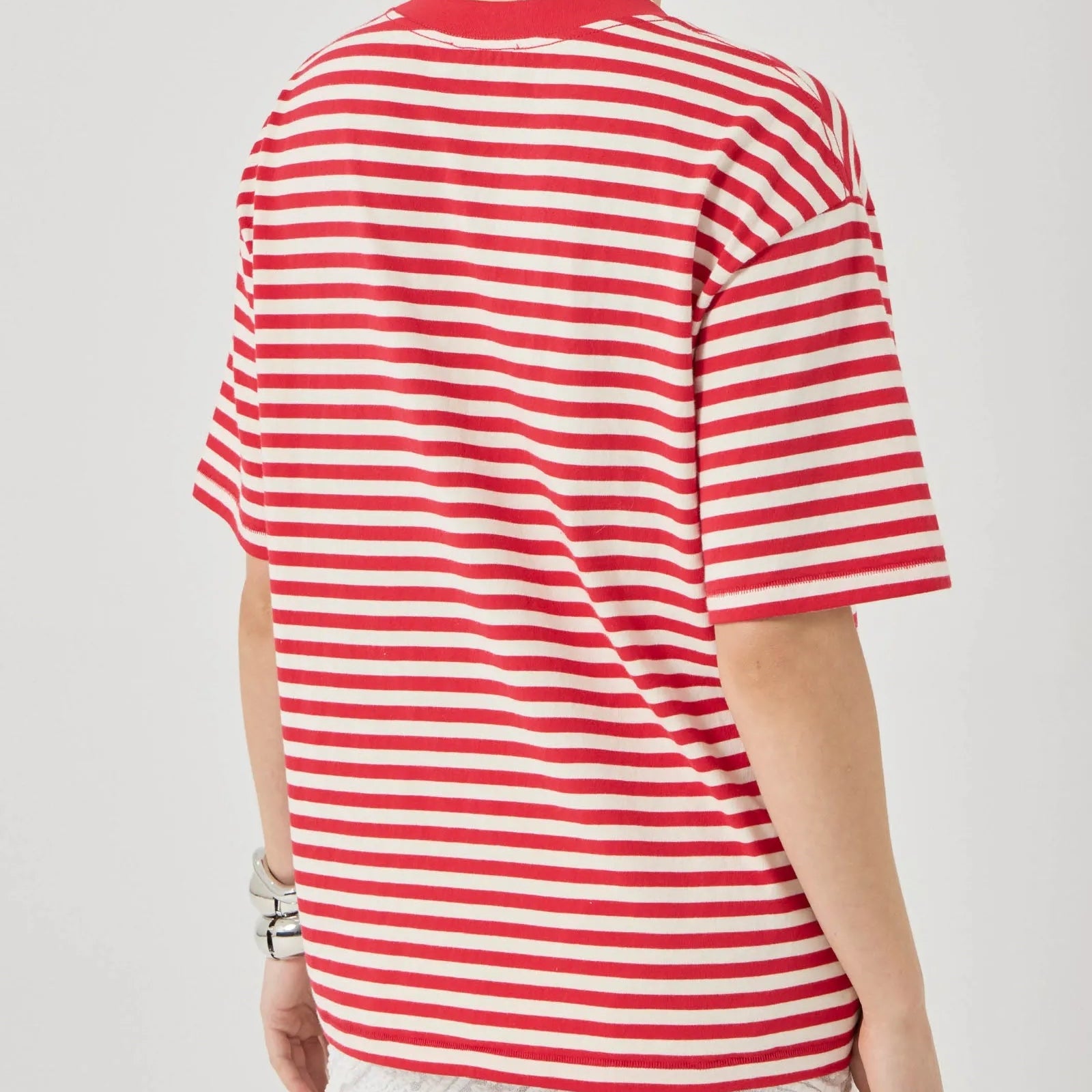 Person wearing a red and white striped shirt on a plain background